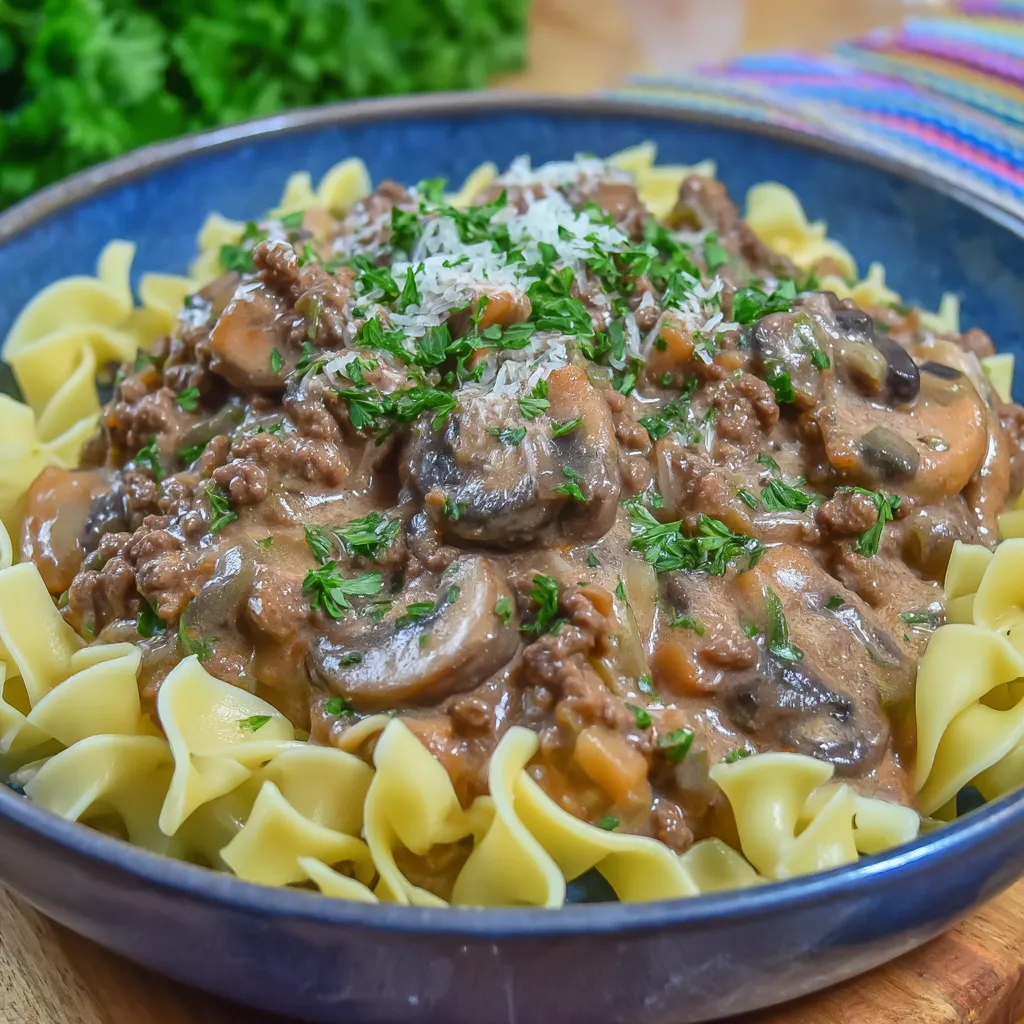 A bowl of pasta with mushrooms and meat.