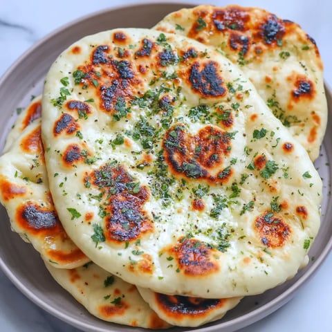 A bowl of pita bread with green toppings.